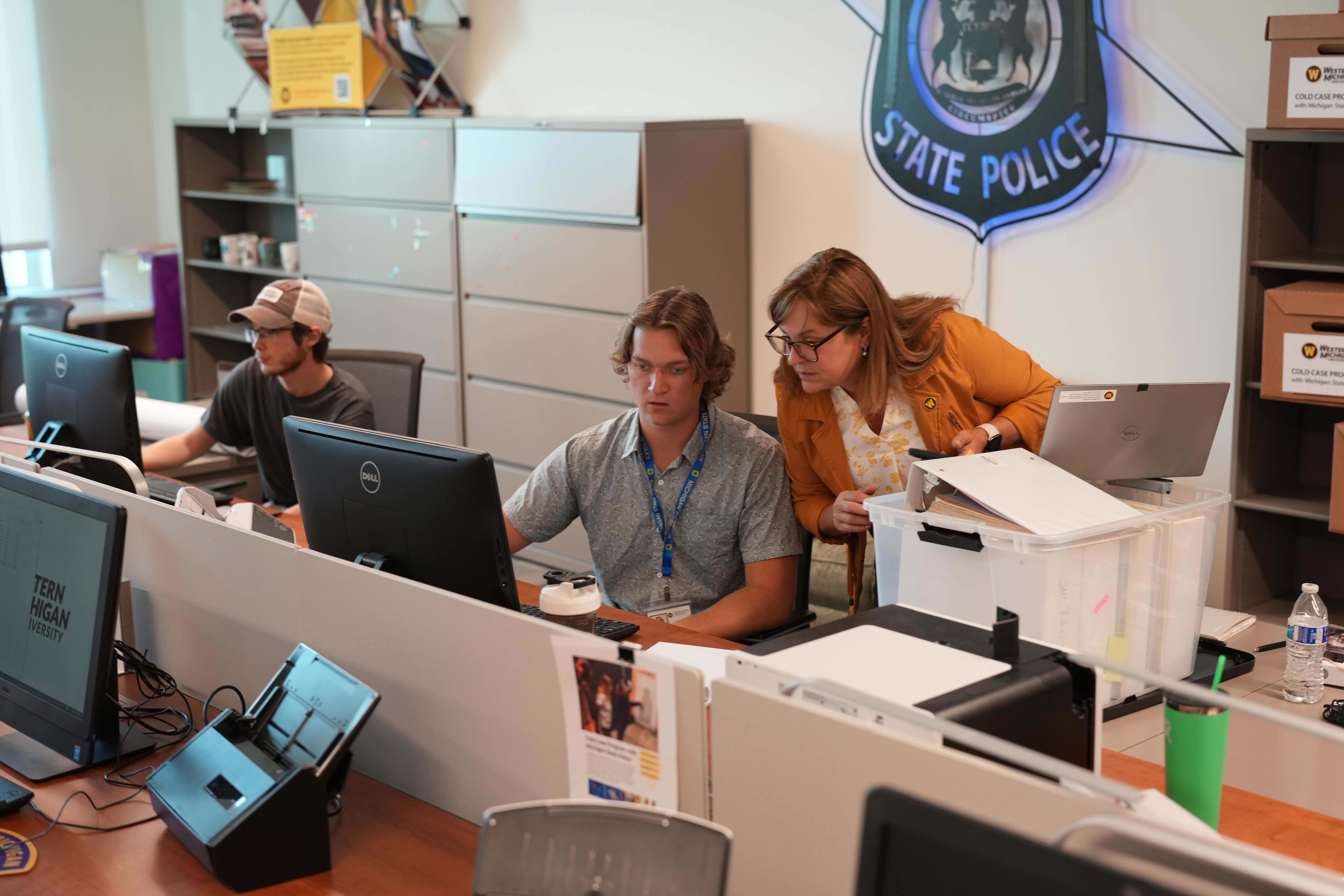 Western Michigan University's Cold Case Program cohorts working with a Michigan State Police detective.