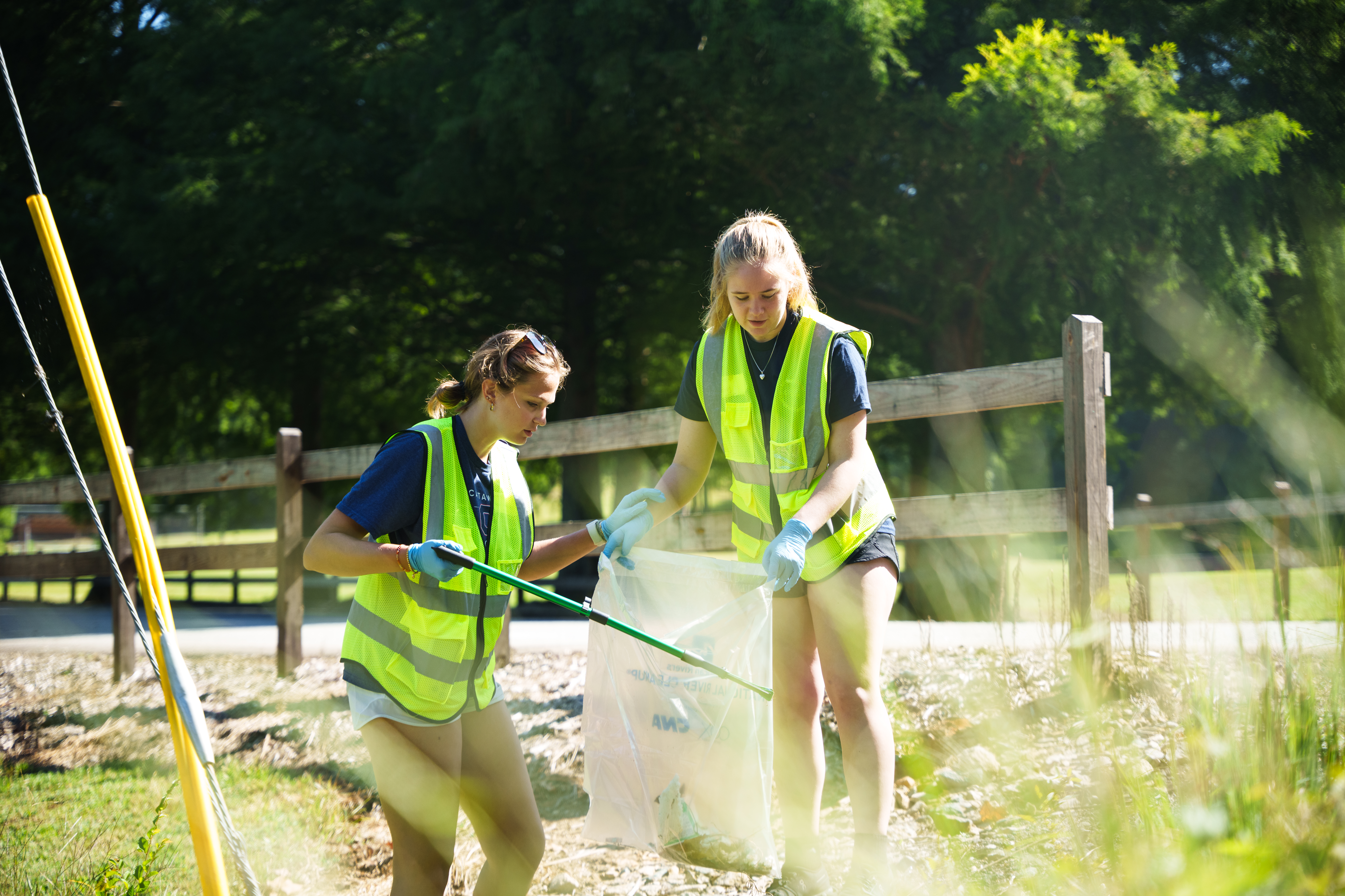 Two Catawba College students pick up roadside trash